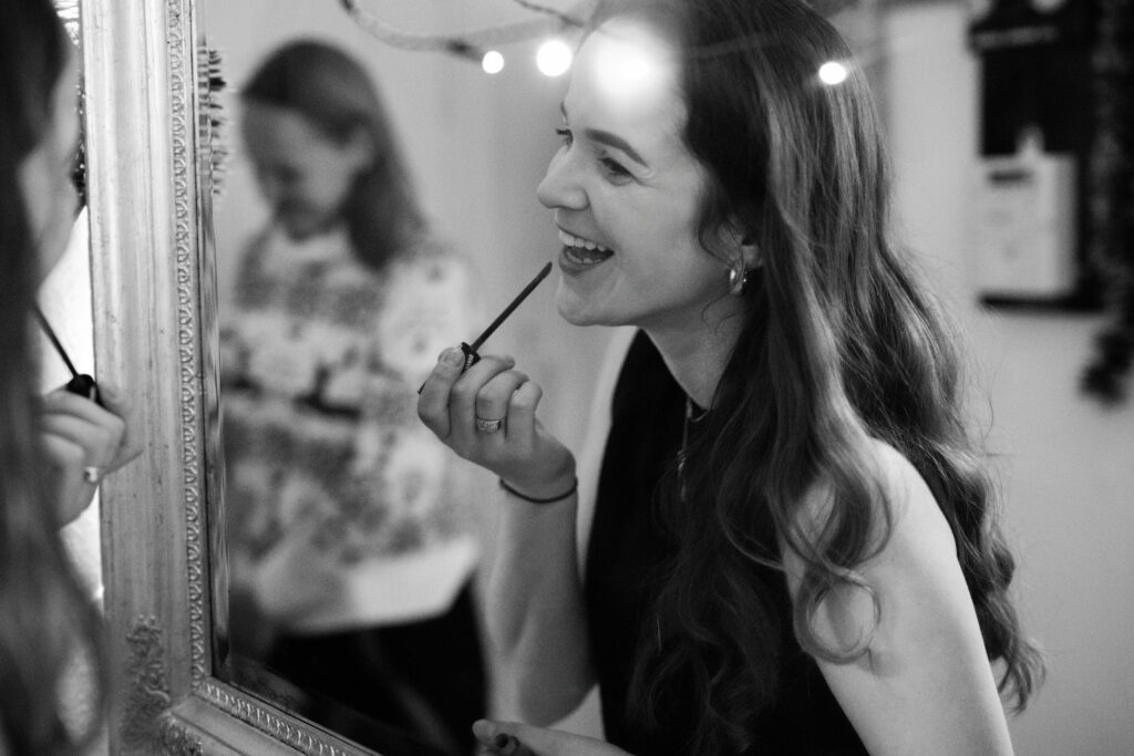 a woman smiling while putting on makeup