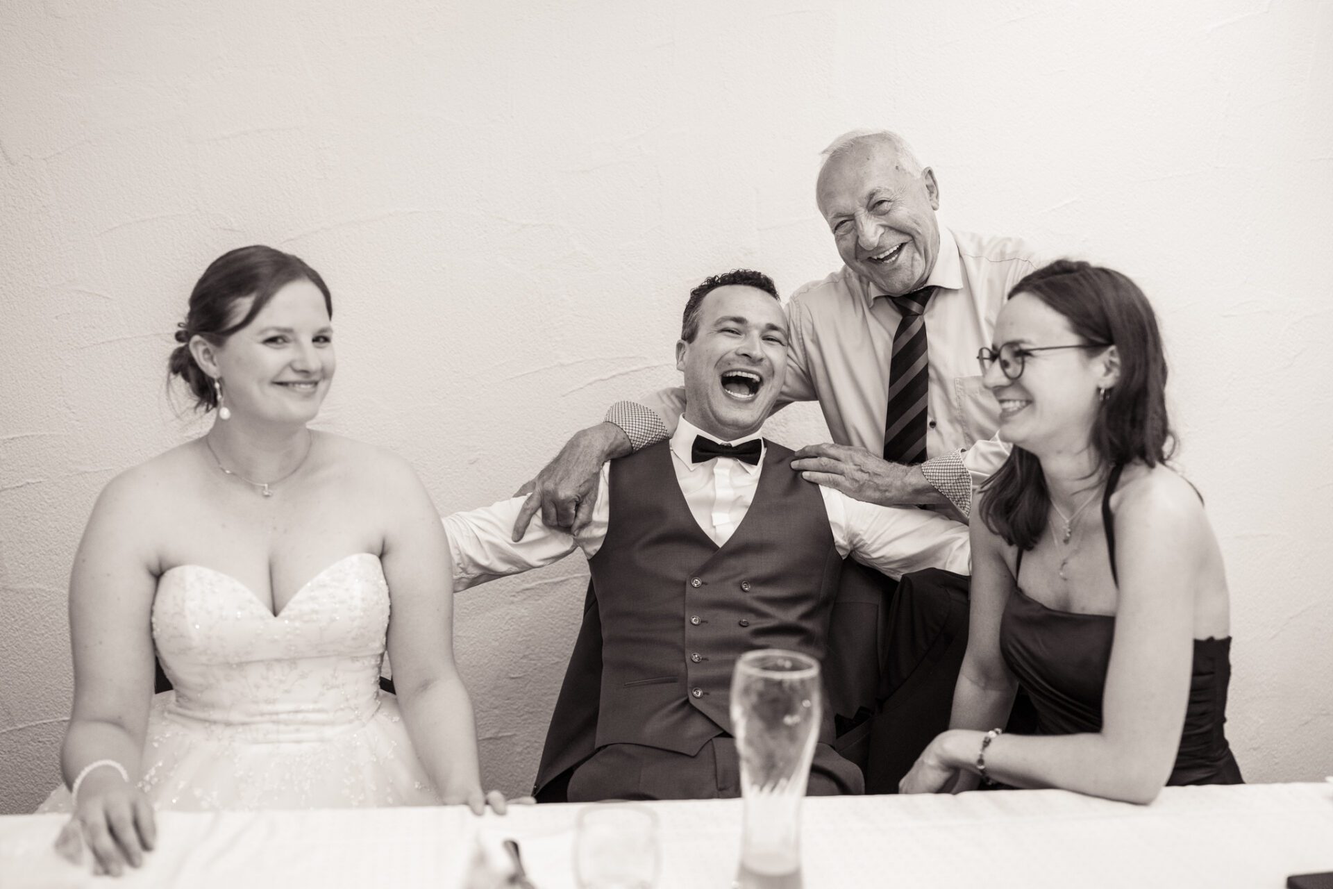 Eine Nahaufnahme eines farbenfrohen Brautstraußes mit weißen, rosafarbenen und pfirsichfarbenen Rosen, lila Distelblüten und grünem Laub, wunderschön eingefangen von einem Hochzeitsfotografen in München. Die perfekte Inspiration für Ihre Hochzeitsfotos. Hochzeitsfotos_Hochzeitsfotograf_München